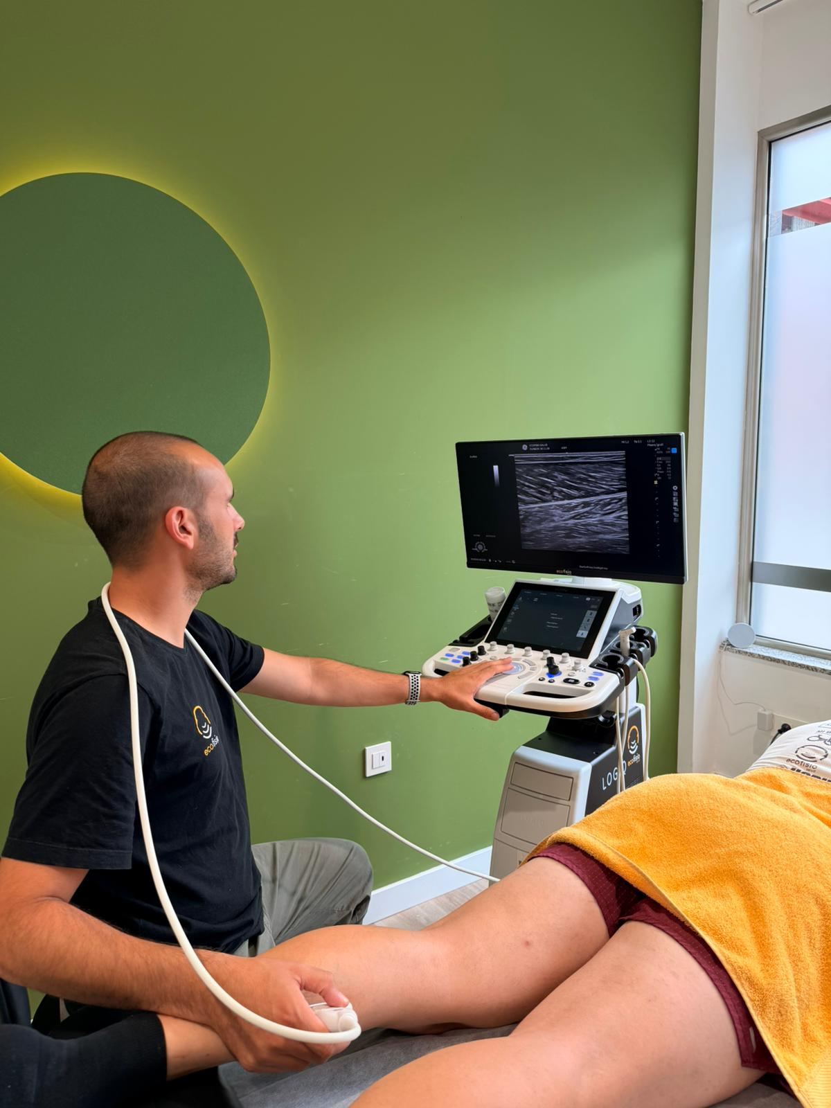 Fisioterapeuta de Ecofisio Salud realizando una ecografía musculoesquelética a un paciente en la clínica de Laviana